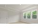 Bedroom with tray ceiling, three windows offering a view of surrounding trees, and neutral walls at 205 Bilge Rd, Ridgeville, SC 29472