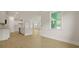 Open-concept living room with modern white kitchen and light-colored hardwood floors and recessed lighting at 205 Bilge Rd, Ridgeville, SC 29472