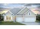 Charming one-story home featuring a three-car garage, well-manicured lawn, and beautiful landscaping at 214 Bilge Rd, Ridgeville, SC 29472