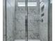 Walk-in shower with marble-patterned tiles, niche, and glass door at 215 Bilge Rd, Ridgeville, SC 29472