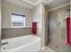 Bathroom showcasing a tub, glass shower, and decorative wallpaper at 225 Seven Farms Dr # 307, Daniel Island, SC 29492