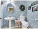 Charming powder room with floral wallpaper, pedestal sink, decorative mirror, and elegant accents at 225 Seven Farms Dr # 307, Daniel Island, SC 29492