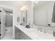 Modern bathroom featuring double sinks, sleek cabinets, and an open door to a separate shower and bath area at 2356 Hut Creek Rd, Johns Island, SC 29455
