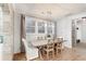 Bright dining room with wooden table and white chairs illuminated by a modern chandelier and natural light at 2356 Hut Creek Rd, Johns Island, SC 29455