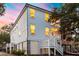Stunning two-story home with charming windows and a beautifully landscaped yard at sunset at 2356 Hut Creek Rd, Johns Island, SC 29455