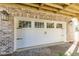 Garage with white door, black hardware, and brick columns at 2356 Hut Creek Rd, Johns Island, SC 29455