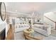 Open-concept living room with white couches, decorative rug, brick archway and access to kitchen at 2356 Hut Creek Rd, Johns Island, SC 29455