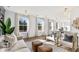 Bright living room with neutral decor, large windows, and wood floors offers comfortable seating at 2356 Hut Creek Rd, Johns Island, SC 29455