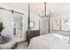 Well-lit main bedroom showcasing a four-poster bed, chandelier, and en-suite bathroom with barn door access at 2356 Hut Creek Rd, Johns Island, SC 29455