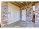 View of the outdoor patio area with brick columns, a wood slat wall, and a door at 2356 Hut Creek Rd, Johns Island, SC 29455
