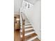 Wooden staircase with white risers and wood railing leads to the upper level of the home at 2356 Hut Creek Rd, Johns Island, SC 29455