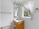 Cozy bathroom showcasing a window with patterned curtains, a neutral countertop, and ample lighting at 241 Howle Ave # G, Charleston, SC 29412