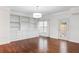 A sunlit living area features a stylish chandelier, custom built-ins, and an entry door to the outside at 241 Howle Ave # G, Charleston, SC 29412