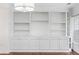 Bright living room featuring custom built-in shelving and cabinetry against dark hardwood floors at 241 Howle Ave # G, Charleston, SC 29412