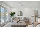 Comfortable living space with large windows, a cozy sofa, a stylish mirror, and a decorative plant at 2553 Hut Creek Rd, Johns Island, SC 29455