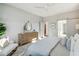 Bright main bedroom featuring a ceiling fan, paneled accent wall, and an ensuite bathroom with a sliding barn door at 2553 Hut Creek Rd, Johns Island, SC 29455