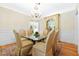 Dining room with a crystal chandelier, glass-top table with upholstered chairs, and hardwood floors at 3171 Pignatelli Cres, Mount Pleasant, SC 29466