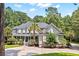 Elegant two-story home featuring a welcoming front porch, complemented by lush landscaping and mature trees at 3171 Pignatelli Cres, Mount Pleasant, SC 29466