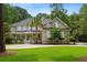 Charming two-story home with a well-manicured lawn, covered front porch, and mature trees in a serene, landscaped setting at 3171 Pignatelli Cres, Mount Pleasant, SC 29466