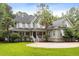 Attractive two-story home featuring a large front lawn, covered porch with white railings, and classic architectural details at 3171 Pignatelli Cres, Mount Pleasant, SC 29466