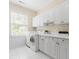 Well-organized laundry room with white cabinetry, countertop space, sink, washer, and dryer at 3171 Pignatelli Cres, Mount Pleasant, SC 29466