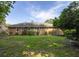 Large backyard with lawn, bench, and brick exterior of the home surrounded by greenery at 344 Canterbury Rd, Charleston, SC 29407