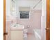 Vintage pink bathroom featuring pink tile, a tub, and a classic sink and mirror at 344 Canterbury Rd, Charleston, SC 29407