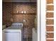 Laundry area in brick room equipped with washer, dryer, shelving and a water heater at 344 Canterbury Rd, Charleston, SC 29407