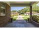 View from a brick porch with ornamental plant pots looking onto a grass and brick street at 344 Canterbury Rd, Charleston, SC 29407