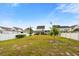 Spacious backyard featuring a well-maintained lawn, young trees, and a charming white fence under a clear blue sky at 347 Ripple Park Dr, Summerville, SC 29486