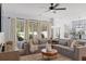 Spacious living room with a large sectional sofa and backyard views through the large windows at 347 Ripple Park Dr, Summerville, SC 29486