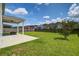Spacious backyard with green grass, a covered patio area, and privacy fencing; great for outdoor activities at 357 Beachgrass Ln, Summerville, SC 29486