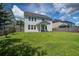 Wide view of home's backyard featuring well-maintained lawn and house's exterior with neutral siding at 357 Beachgrass Ln, Summerville, SC 29486
