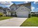 Charming two-story home with a large driveway, attached garage, and well-maintained front lawn and landscaping at 357 Beachgrass Ln, Summerville, SC 29486