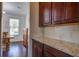 Granite countertops, dark wood cabinets and view of a dining area in this kitchen at 357 Beachgrass Ln, Summerville, SC 29486