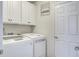 Bright laundry room with white cabinets, a white washer and dryer, and a door to other parts of the home at 357 Beachgrass Ln, Summerville, SC 29486