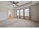 Spacious main bedroom with neutral carpet, a ceiling fan, three windows and entry to the bathroom at 357 Beachgrass Ln, Summerville, SC 29486