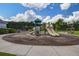 Community playground featuring multiple slides and play structures set on a mulch base with nearby benches at 357 Beachgrass Ln, Summerville, SC 29486