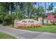 Entrance sign for 'The Oaks' community, featuring stone pillars and colorful flowerbeds, set along the roadside at 357 Beachgrass Ln, Summerville, SC 29486