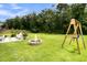 Expansive backyard with lush lawn, fire pit, wooden swing set and patio with seating, perfect for outdoor enjoyment at 3789 Tupelo Branch Row, Mount Pleasant, SC 29429