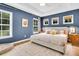 Stylish bedroom featuring a large bed, hardwood floors, multiple windows, and neutral tones at 3789 Tupelo Branch Row, Mount Pleasant, SC 29429