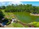 Aerial view of a landscaped community lake with greenery and a sitting area with benches and a fire pit at 391 Evian Way, Mount Pleasant, SC 29464