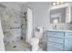Bathroom featuring a marble walk-in shower, blue vanity with drawers, a sink, toilet and a decorative mirror at 391 Evian Way, Mount Pleasant, SC 29464