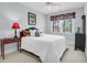 Bedroom featuring a plush bed with decorative pillows, a window with floral curtains, and a dark bedside table at 391 Evian Way, Mount Pleasant, SC 29464