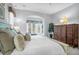 Light, airy bedroom featuring a white bed with accent pillows, a seating area, and French doors to the outdoors at 391 Evian Way, Mount Pleasant, SC 29464