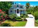 Charming two-story home with a red door, white stairs, beautifully landscaped yard, and a long driveway at 391 Evian Way, Mount Pleasant, SC 29464