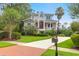 Beautiful two-story home featuring a red door, a columned porch and a brick-paved driveway at 391 Evian Way, Mount Pleasant, SC 29464