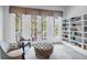 Cozy sitting area with chairs, an ottoman, and a bookshelf, showcasing a relaxing space with natural light at 391 Evian Way, Mount Pleasant, SC 29464
