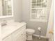 Cozy bathroom featuring a vanity with countertop, toilet, window with blinds, and shower with curtain at 407 Thomaston Ave, Summerville, SC 29485