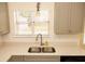 A kitchen sink with a large window with blinds, as well as tiled backsplash and gray cabinets at 407 Thomaston Ave, Summerville, SC 29485